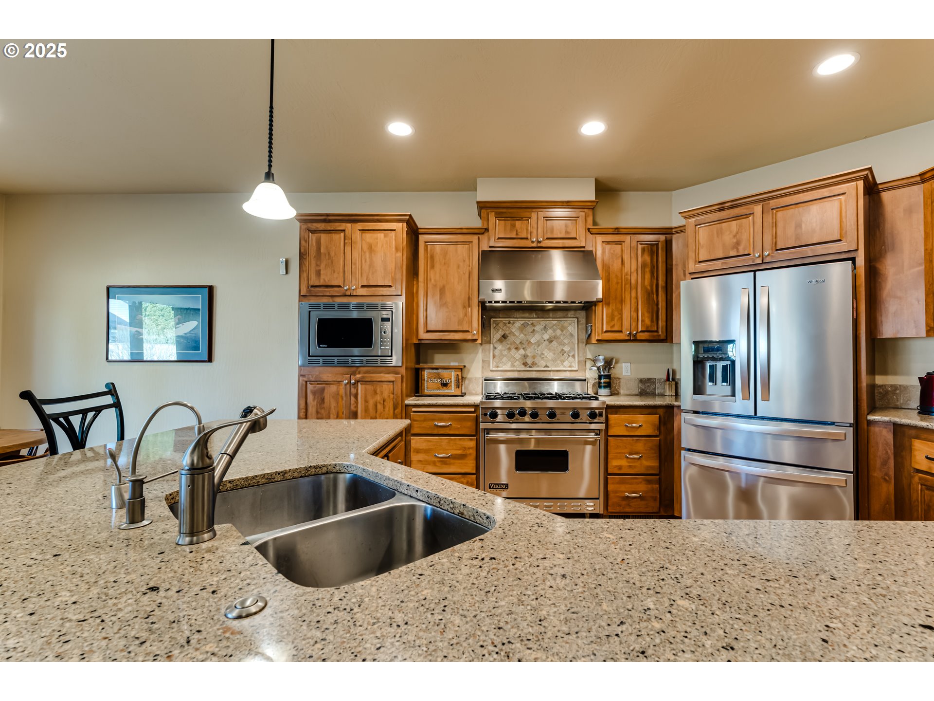 3351 Cape Hatteras Drive Eugene, OR 97408 - Photo 18 of 47 a kitchen with stainless steel appliances a sink a stove a refrigerator cabinets a dining table and chairs