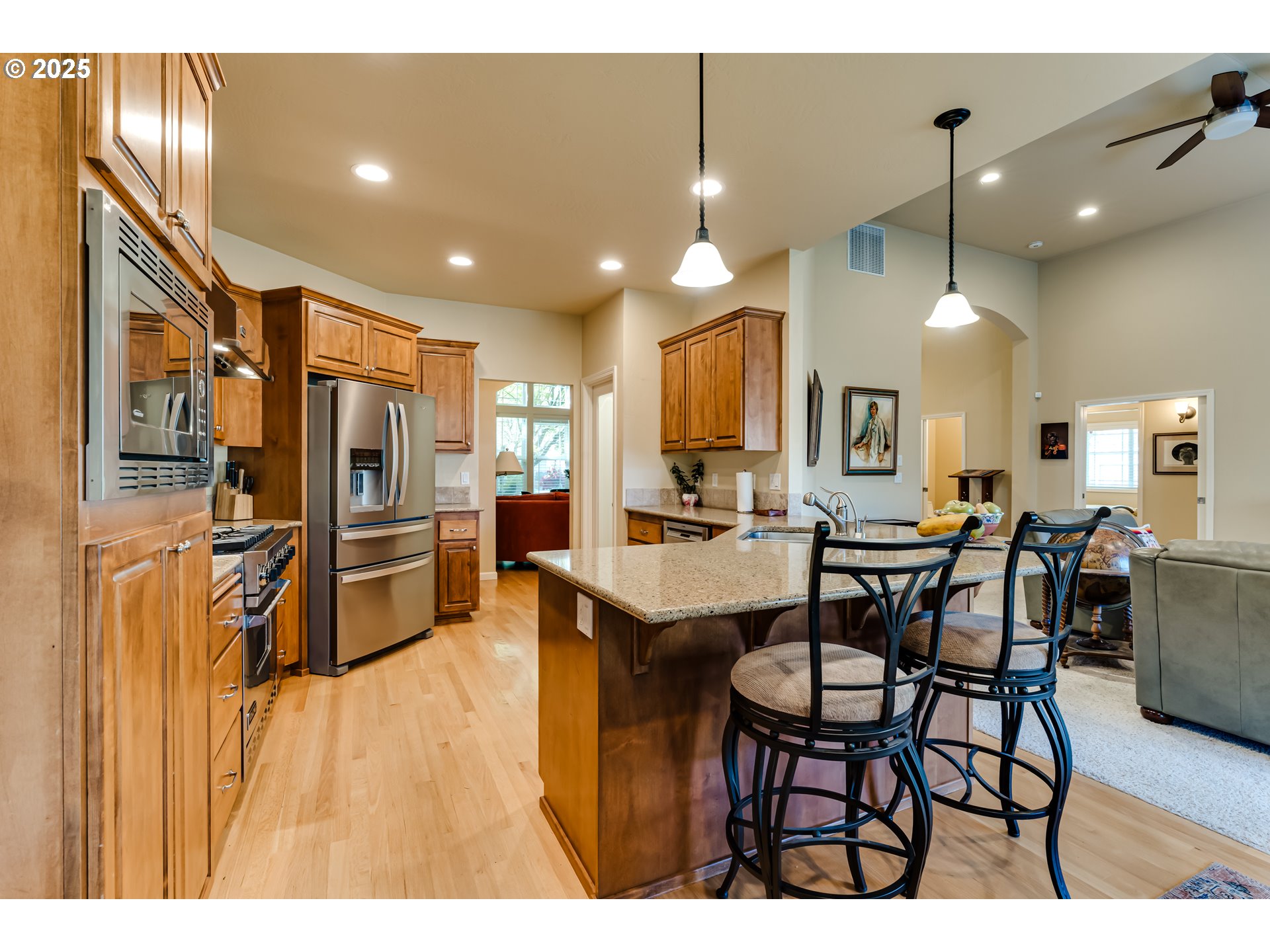 3351 Cape Hatteras Drive Eugene, OR 97408 - Photo 19 of 47 a open kitchen with stainless steel appliances kitchen island granite countertop a table chairs and a refrigerator