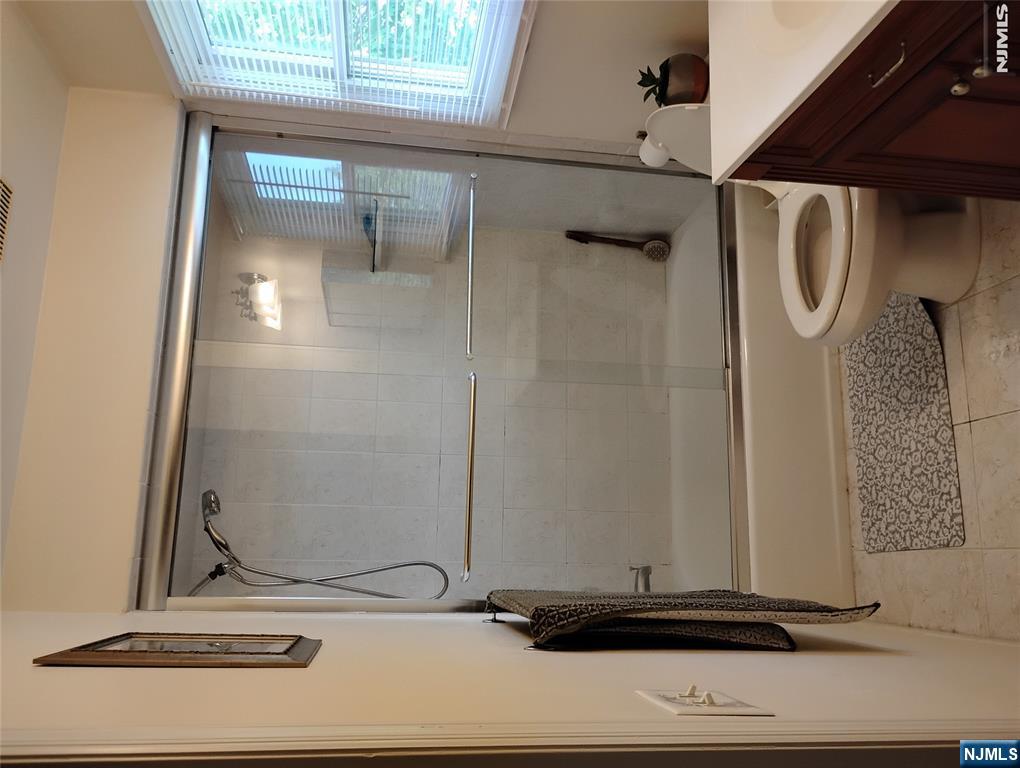 277 3rd Street Hackensack, NJ 07601 - Photo 12 of 14 a bathroom with a granite countertop bathtub shower and toilet