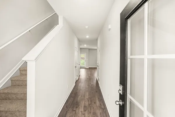 a view of a hallway with wooden floor and staircase