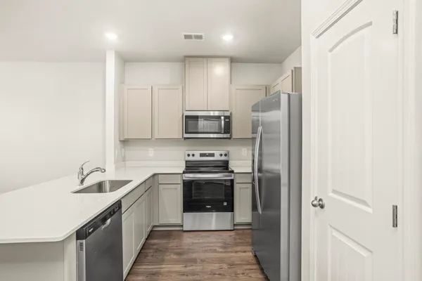 a kitchen with stainless steel appliances granite countertop a sink and a refrigerator