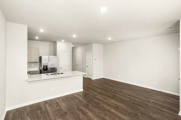 a view of a kitchen with kitchen island a sink dishwasher and a stove with wooden floor