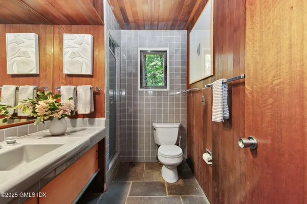 a bathroom with a sink a toilet and window