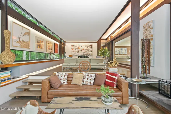 a living room with patio furniture and a floor to ceiling window