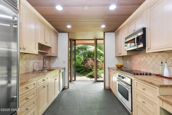 a kitchen with stainless steel appliances granite countertop a stove a sink and a microwave