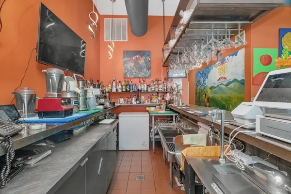 a kitchen with stainless steel appliances granite countertop a table chairs and a refrigerator