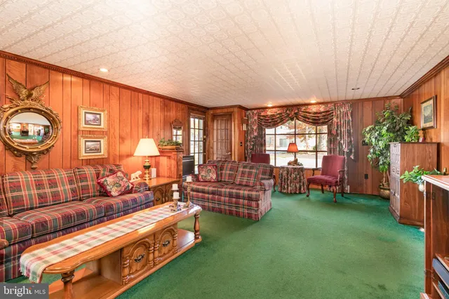 a living room with furniture a rug and a floor to ceiling window