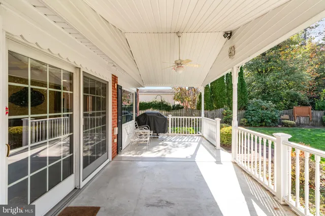 a view of backyard of house with wooden deck and seating