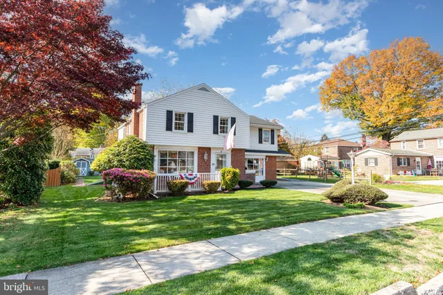 a front view of a house with a garden and trees