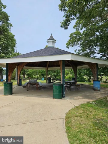 a backyard of a house with table and chairs under an umbrella