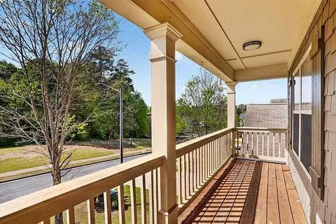 a view of a balcony with chairs and wooden floor