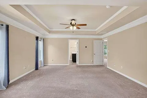 a view of a livingroom with a chandelier fan and windows