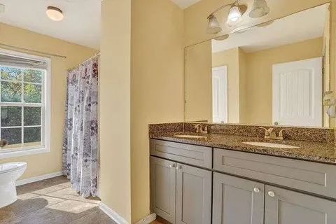 a bathroom with a granite countertop sink a mirror a and a shower