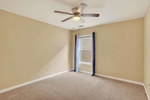 an empty room with closet and ceiling fan