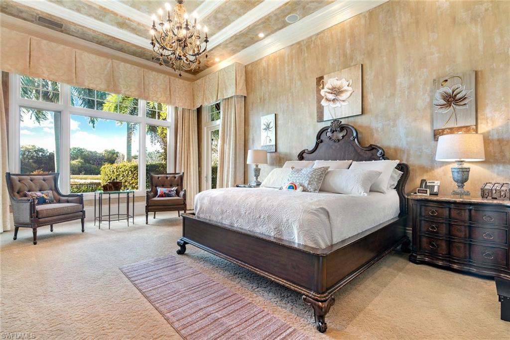 14927 Celle Way Naples, FL 34110 - Photo 15 of 31 a bedroom with a large bed and a chandelier