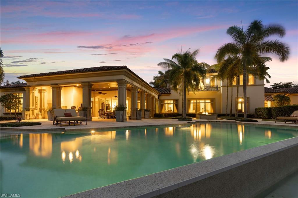 14927 Celle Way Naples, FL 34110 - Photo 5 of 31 a view of a swimming pool with a lawn chairs and lake view