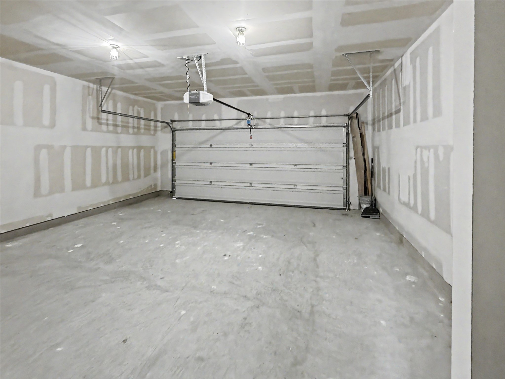 229 Night Riders Way Jarrell, TX 76537 - Photo 14 of 19 A spacious unfinished garage with a concrete floor and a roll-up door.