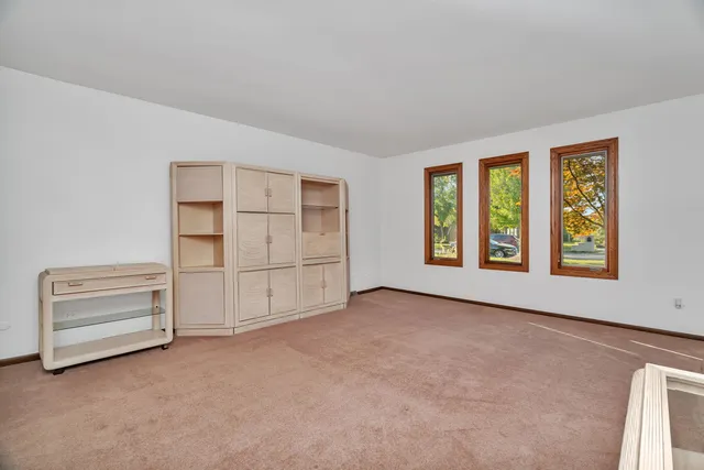 an empty room with a empty space & windows