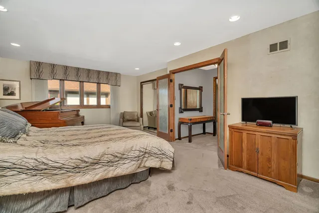 a spacious bedroom with a bed and a dresser