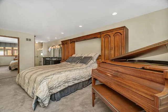 a spacious bedroom with a bed dresser and a window