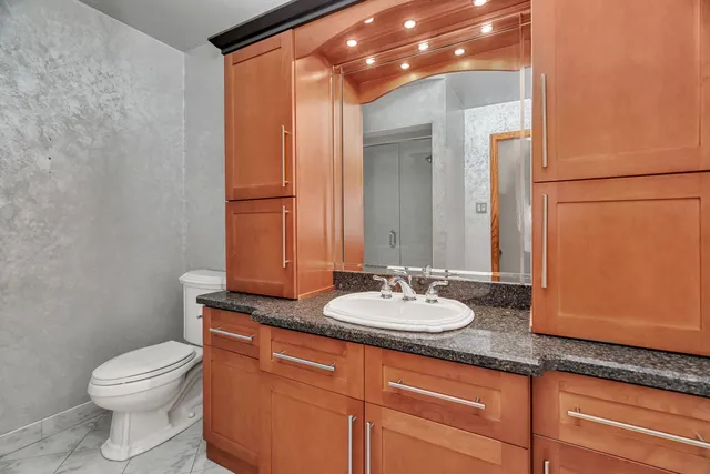 a white toilet next to a bathroom