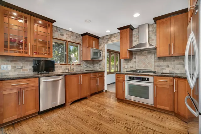 a kitchen with stainless steel appliances granite countertop a stove a sink and a microwave