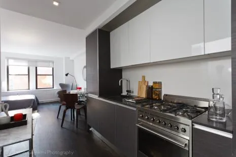 a kitchen with a stove and a white wooden cabinets