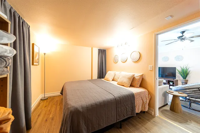 a bedroom with a bed and wooden floor