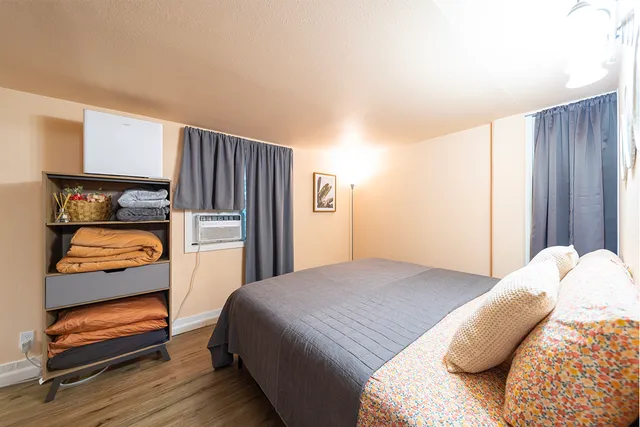 a bedroom with a bed and wooden floor