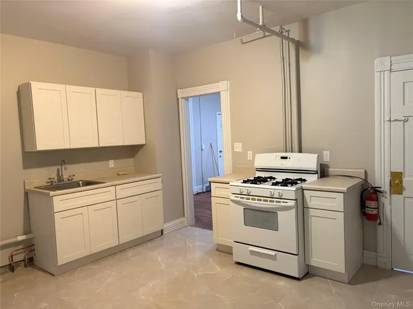 a kitchen with white cabinets and white appliances