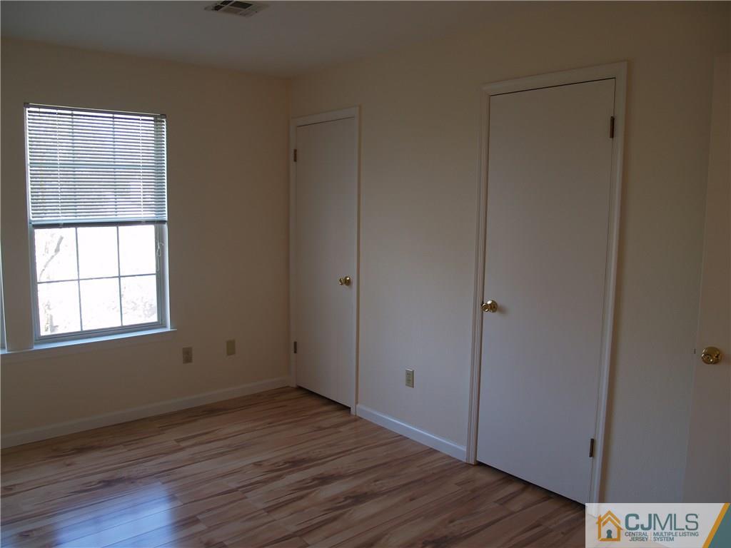 18 High Pond Lane, Unit 18 Bedminster, NJ 07921 - Photo 13 of 19 an empty room with wooden floor and windows