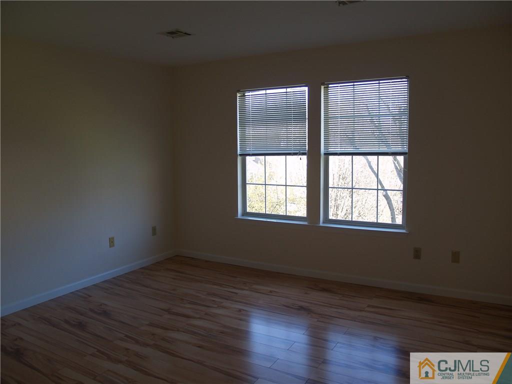 18 High Pond Lane, Unit 18 Bedminster, NJ 07921 - Photo 14 of 19 an empty room with wooden floor and windows