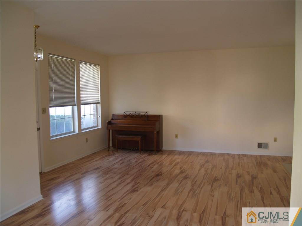 18 High Pond Lane, Unit 18 Bedminster, NJ 07921 - Photo 3 of 19 a room with a piano and wooden floor