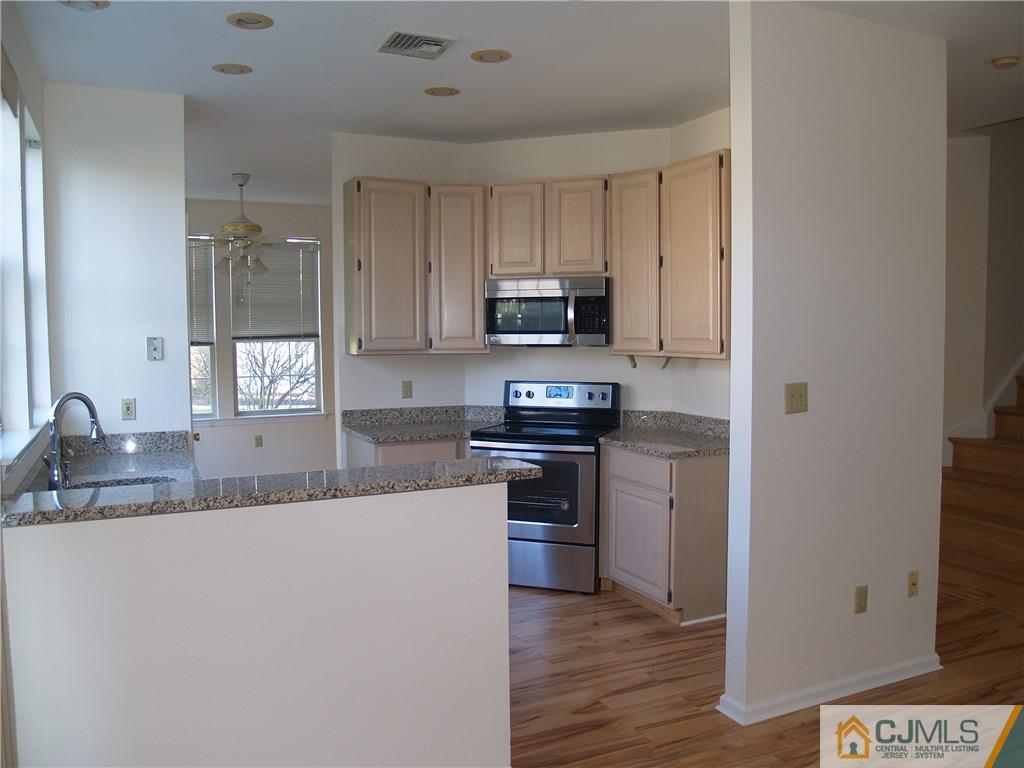 18 High Pond Lane, Unit 18 Bedminster, NJ 07921 - Photo 9 of 19 a kitchen with kitchen island granite countertop a sink cabinets and stainless steel appliances