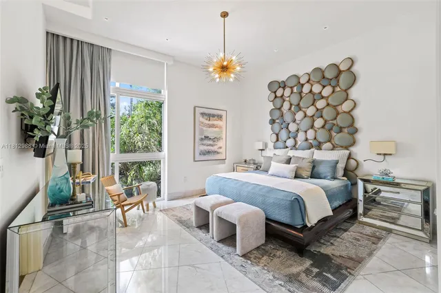 a bedroom with a bed and a chandelier