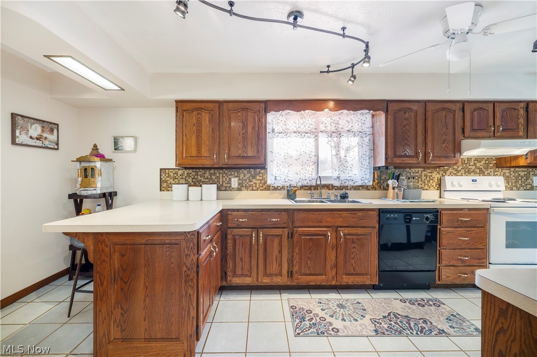 6597 York Road Parma Heights, OH 44130 - Photo 17 of 34 Kitchen with light tile floors, dishwasher, white range with electric cooktop, backsplash, and sink