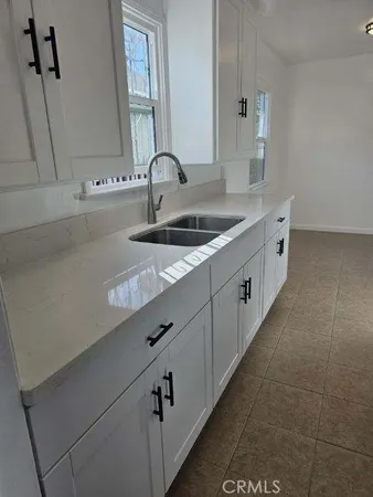 a bathroom with a granite countertop sink a mirror and a bathtub