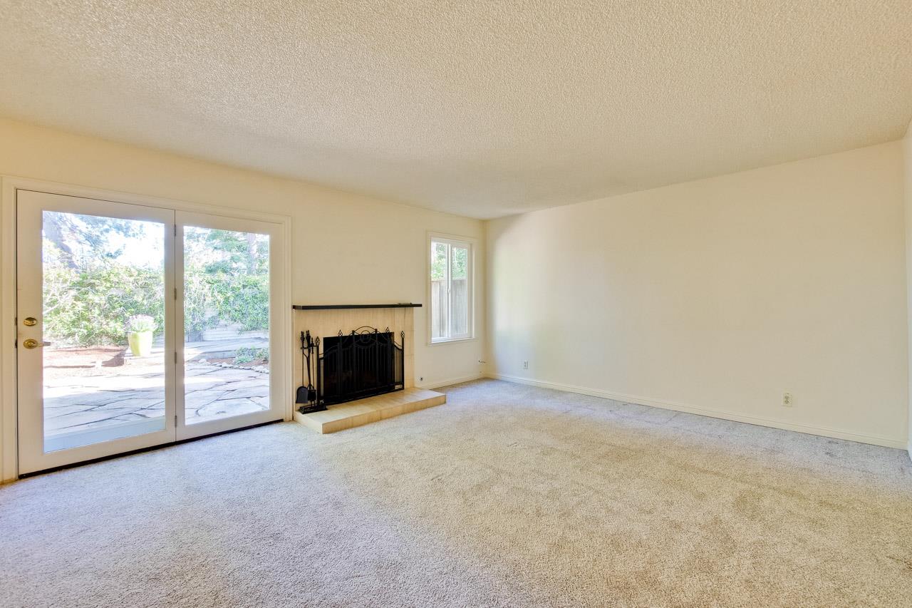22903 Longdown Road Cupertino, CA 95014 - Photo 11 of 42 an empty room with a fireplace and large window