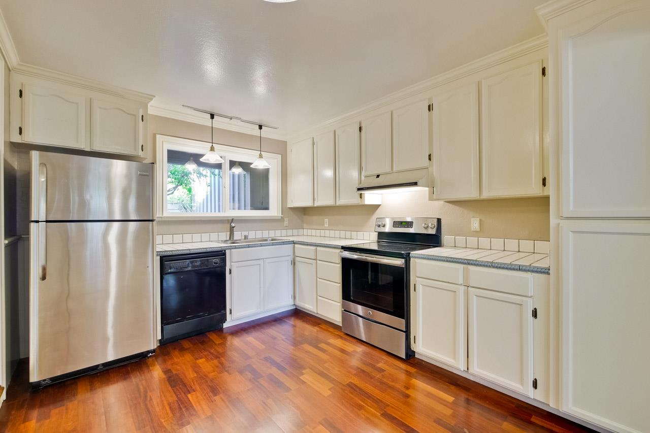 22903 Longdown Road Cupertino, CA 95014 - Photo 13 of 42 a kitchen with stainless steel appliances granite countertop a refrigerator stove and white cabinets
