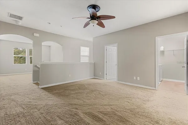 an empty room with closet and a chandelier fan