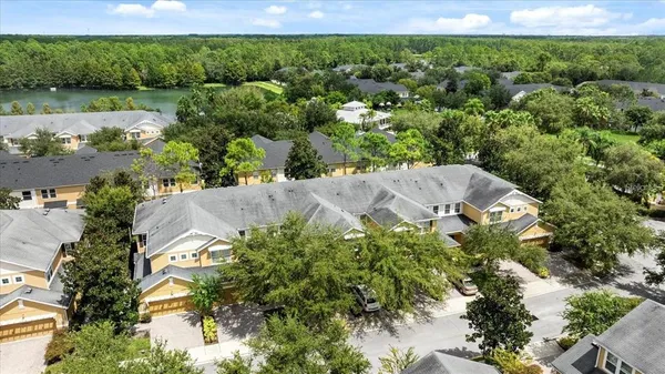 an aerial view of residential houses with outdoor space and trees