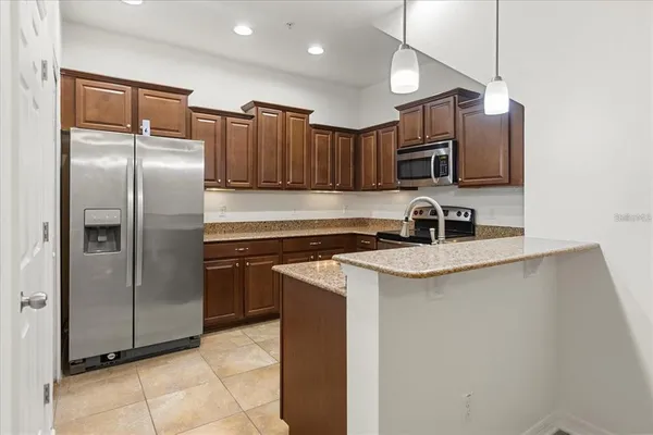 a kitchen with stainless steel appliances granite countertop a sink stove and microwave
