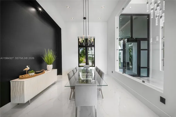 a living room with stainless steel appliances furniture a large window and a refrigerator