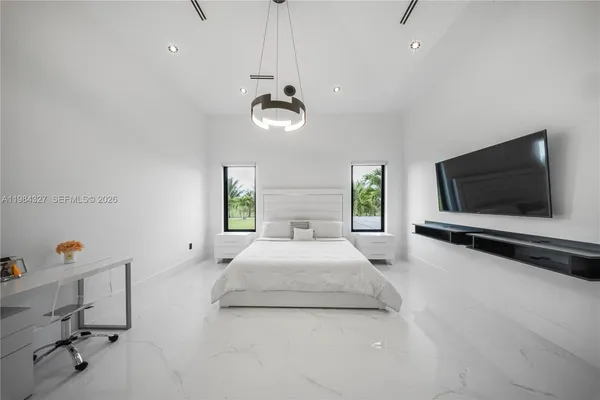a large bedroom with a bed and a view of living room