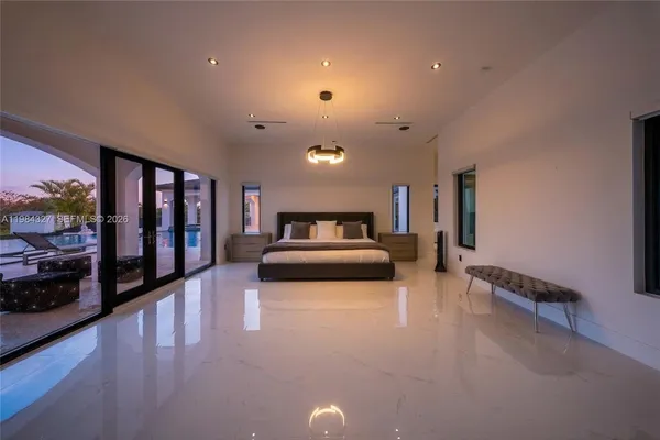 a large white kitchen with granite countertop a sink and cabinets