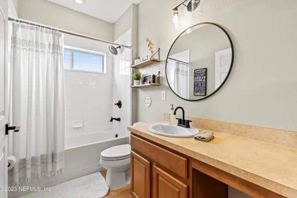 a bathroom with a toilet a sink a mirror and a shower