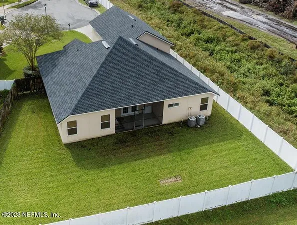 a aerial view of a house with a yard and garage