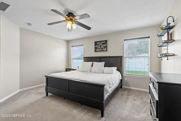 a bedroom with a bed and a ceiling fan