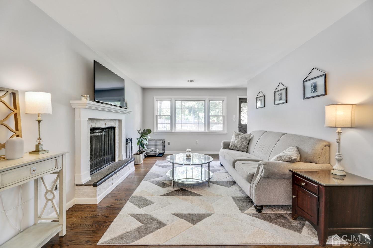 199 Jordan Road Colonia, NJ 07067 - Photo 3 of 24 a living room with furniture a fireplace and a flat screen tv