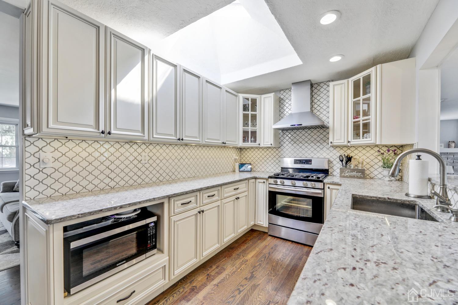 199 Jordan Road Colonia, NJ 07067 - Photo 6 of 24 a kitchen with stainless steel appliances granite countertop a stove and white cabinets